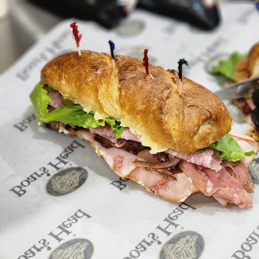 Boar's Head deli sandwich stacked with turkey, ham and roast beef on a fresh baguette