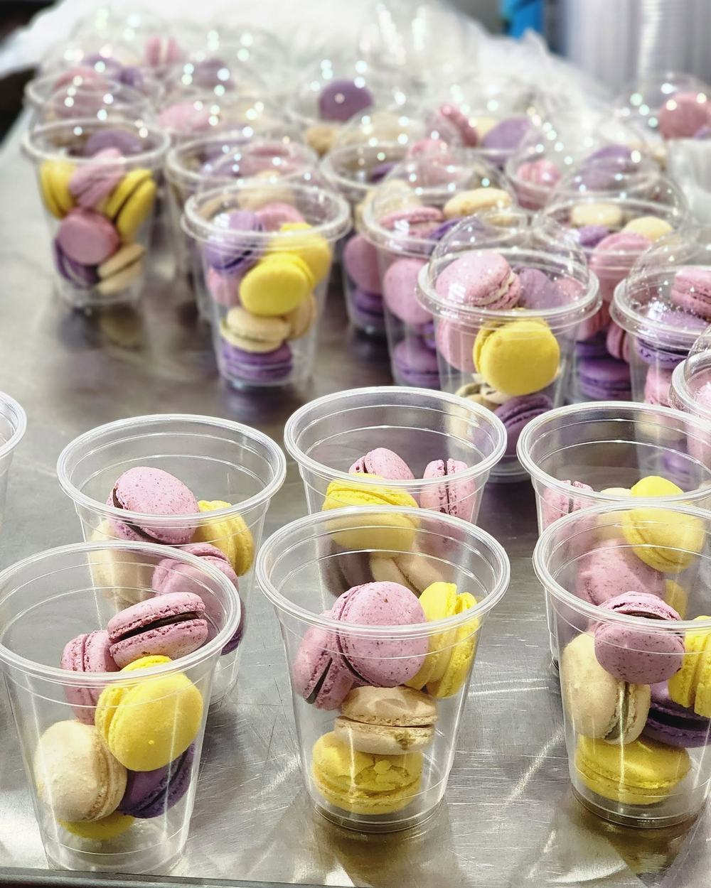 Cups of pink, purple, yellow and cream macarons ready for pickup at Bizinka Bakery