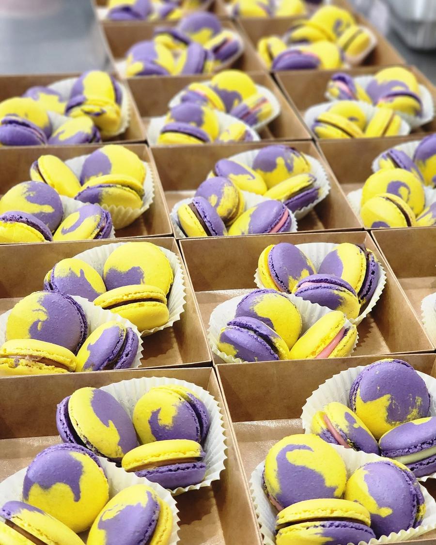 Purple and yellow marbled macarons boxed in rows at Bizinka Bakery